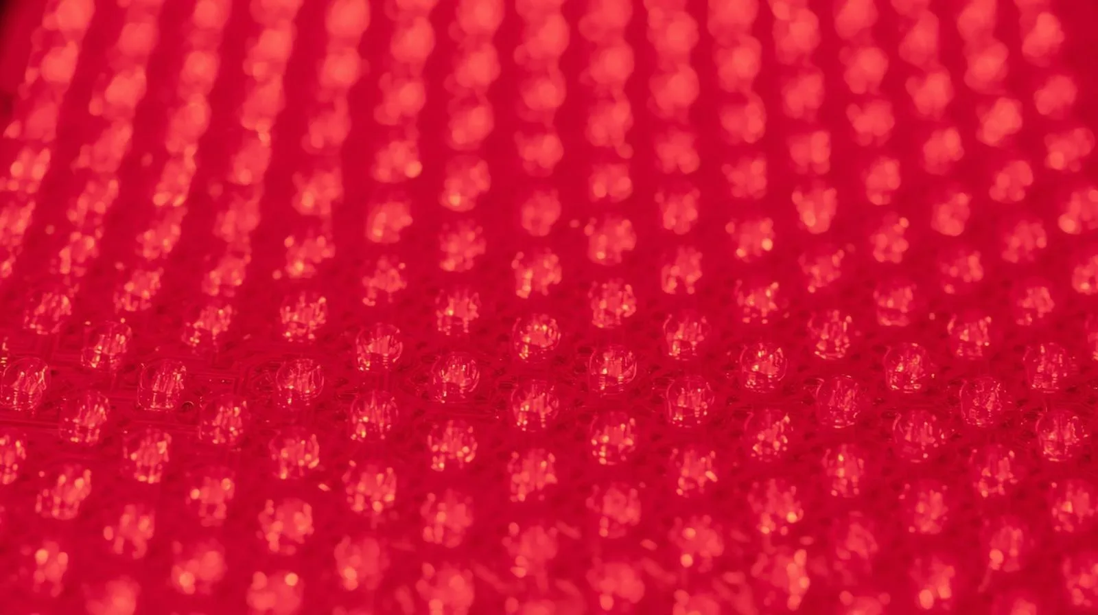 Macro close-up on the precise, clean grid of emitters on a clinical-grade LED light therapy panel.
